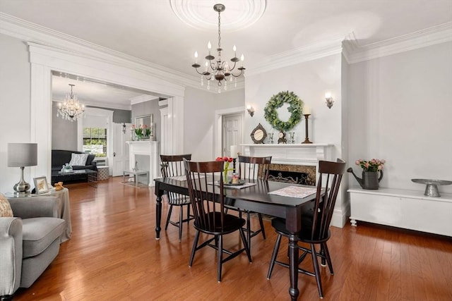 dining space with a chandelier, wood finished floors, and crown molding