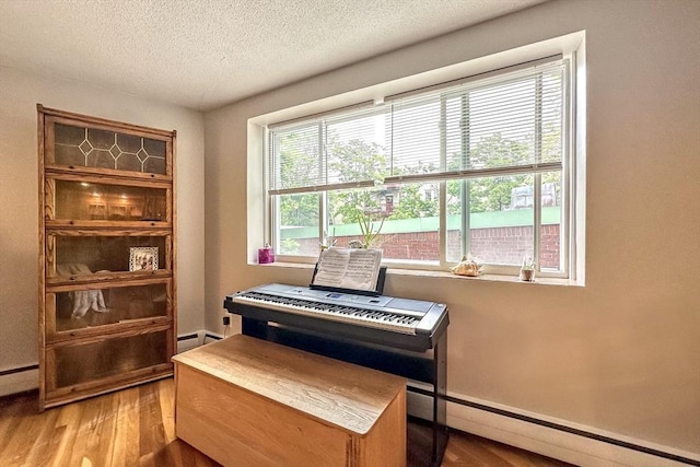 50 Green St Unit 312, Brookline, MA 02446 - living area featuring wood finished floors, a textured ceiling, baseboard heating, and a baseboard heating unit