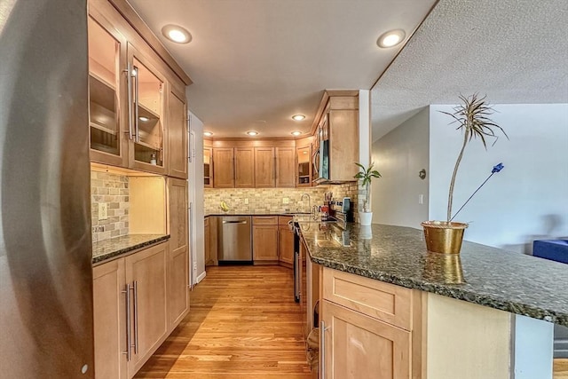 50 Green St Unit 312, Brookline, MA 02446 - kitchen with stainless steel appliances, a peninsula, light wood finished floors, glass insert cabinets, and recessed lighting