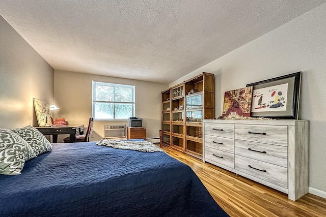 50 Green St Unit 312, Brookline, MA 02446 - bedroom featuring light wood-type flooring, a textured ceiling, and a wall mounted AC