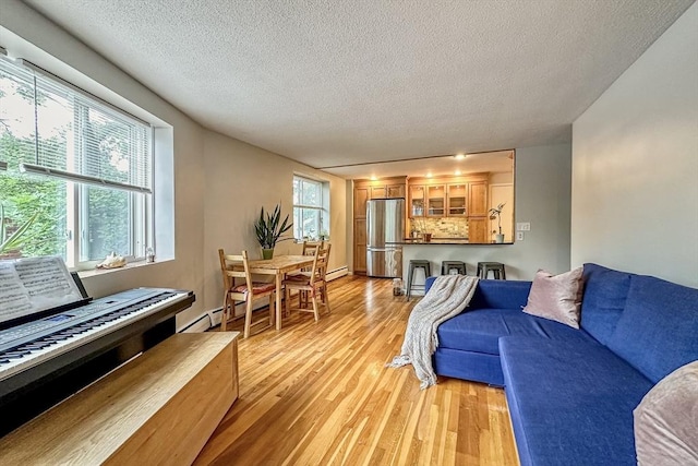 50 Green St Unit 312, Brookline, MA 02446 - living room with light wood finished floors, a textured ceiling, and a baseboard heating unit