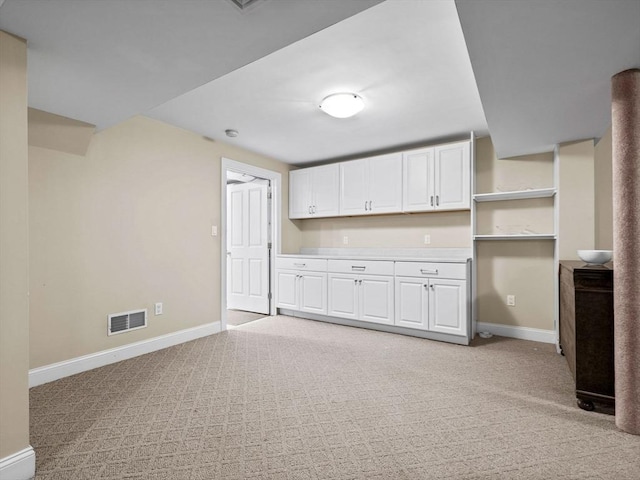 23 Chandler St, Newton, MA 02458 - kitchen featuring open shelves, light carpet, baseboards, white cabinetry, and light countertops