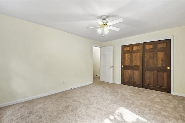 unfurnished bedroom featuring a closet, a ceiling fan, baseboards, and carpet floors