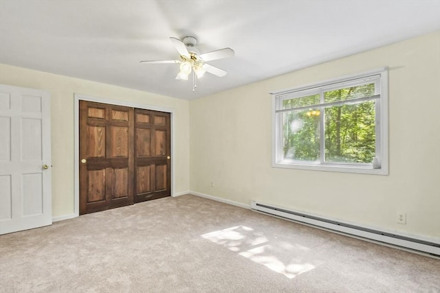 unfurnished bedroom with a closet, carpet flooring, a baseboard heating unit, and baseboards