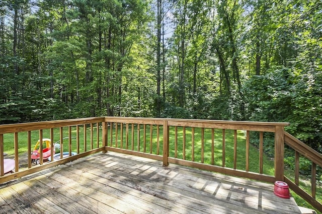 wooden deck with a yard and a forest view