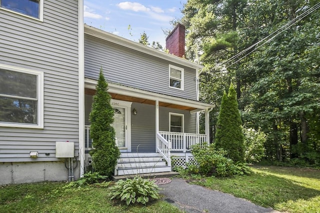 view of front of home featuring covered porch and a chimney