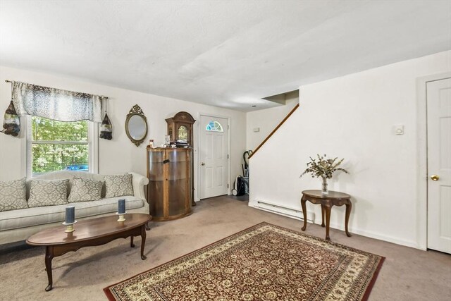 carpeted living room featuring a baseboard heating unit and baseboards