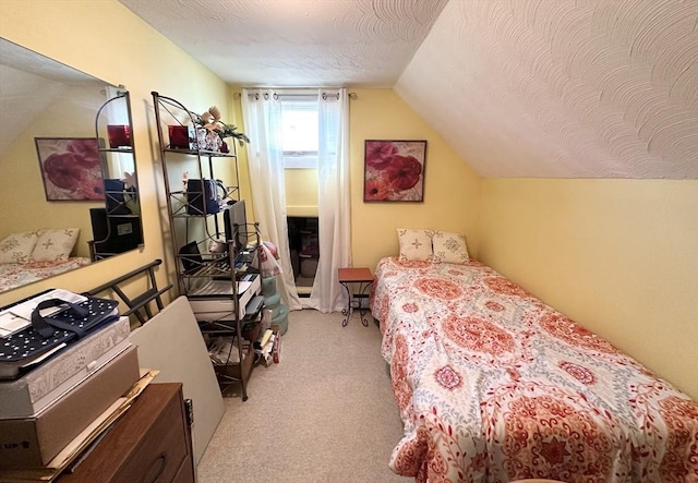 bedroom with vaulted ceiling, light colored carpet, and a textured ceiling