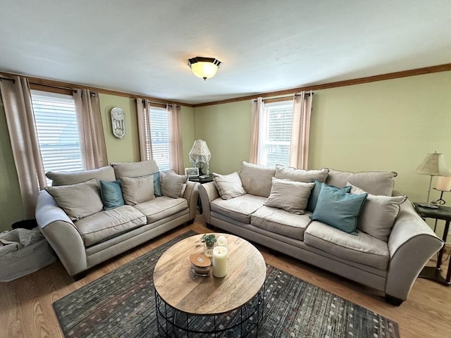 living room with plenty of natural light, wood finished floors, and ornamental molding