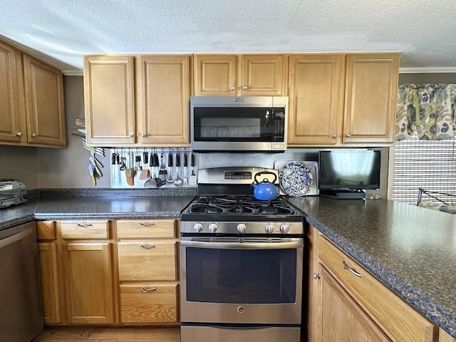 kitchen with a textured ceiling, dark countertops, and stainless steel appliances