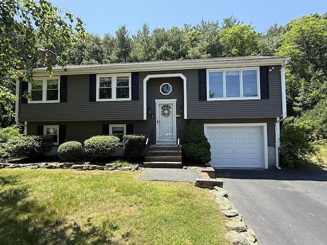 69 Hickory Dr, Raynham, MA 02767 - raised ranch featuring an attached garage, a front lawn, and driveway