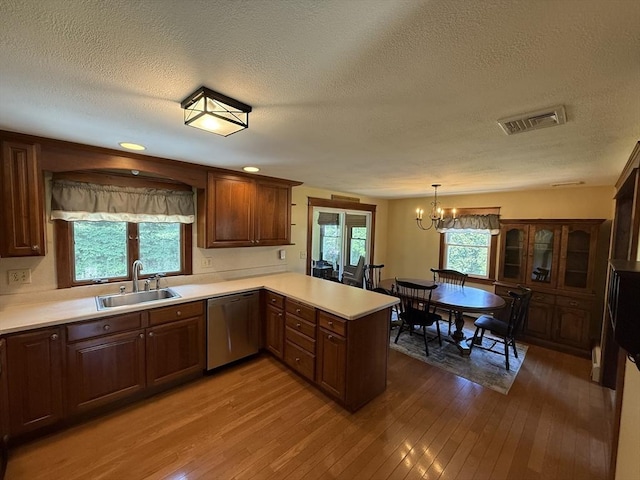 69 Hickory Dr, Raynham, MA 02767 - kitchen featuring stainless steel dishwasher, a peninsula, wood-type flooring, a textured ceiling, and plenty of natural light