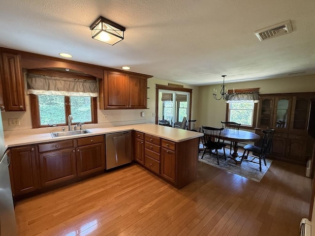69 Hickory Dr, Raynham, MA 02767 - kitchen with stainless steel dishwasher, a peninsula, a baseboard heating unit, light wood-style flooring, and a textured ceiling