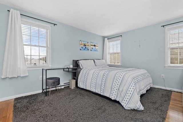 bedroom featuring baseboards and wood finished floors