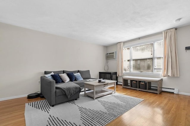 living area featuring baseboards, wood finished floors, and a wall mounted AC