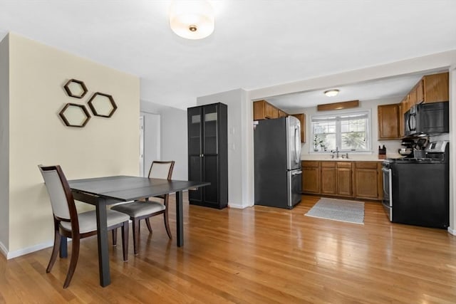 dining area with light wood-style flooring and baseboards