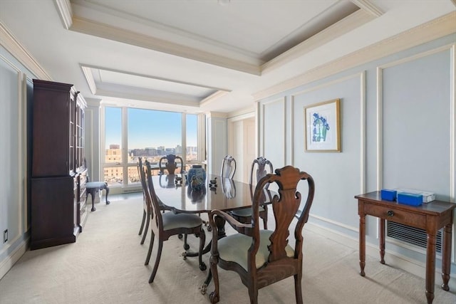 dining area with a raised ceiling, ornamental molding, floor to ceiling windows, and light carpet