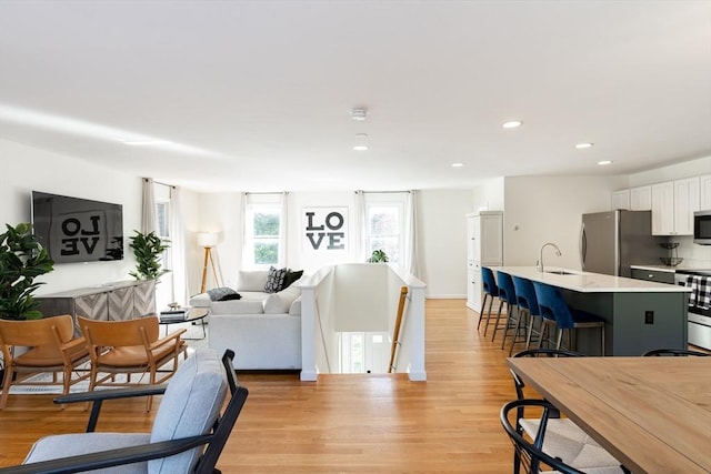 living room with sink and light hardwood / wood-style flooring