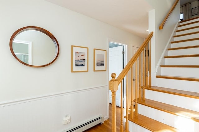 stairway with hardwood / wood-style flooring and baseboard heating