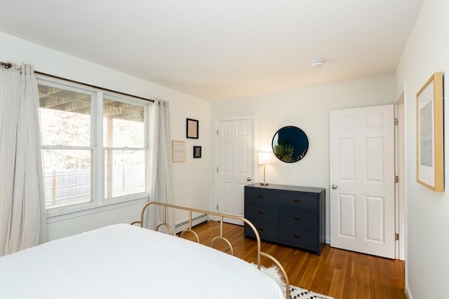 bedroom featuring baseboard heating and wood-type flooring