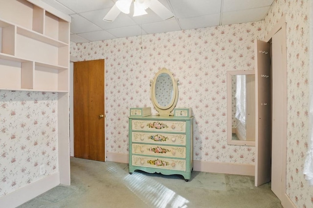 unfurnished bedroom with carpet floors, a paneled ceiling, and wallpapered walls