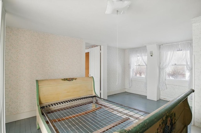 bedroom with wallpapered walls, baseboards, and wood finished floors