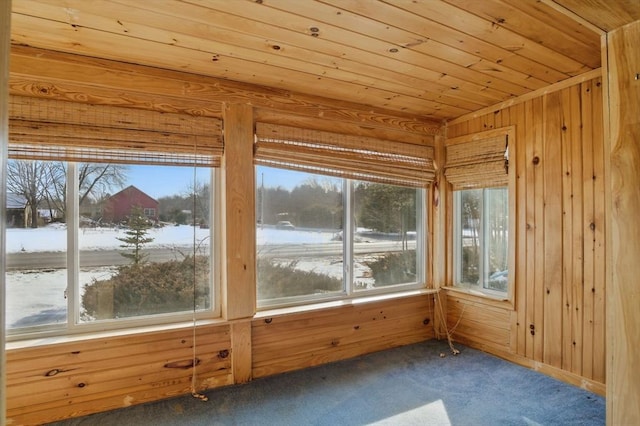 unfurnished sunroom featuring wood ceiling and plenty of natural light