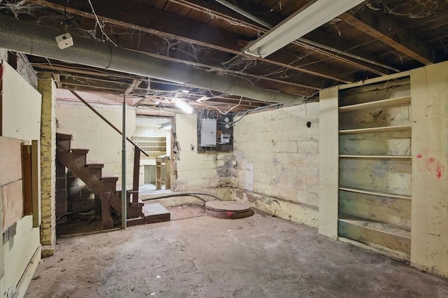 unfinished basement with stairway and electric panel