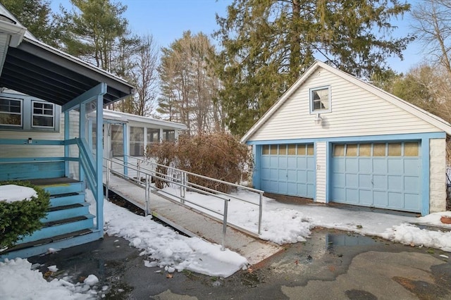 snow covered garage featuring a detached garage