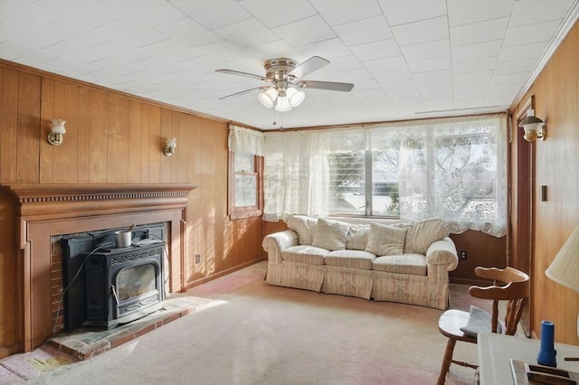 interior space featuring light carpet, a wood stove, and wooden walls