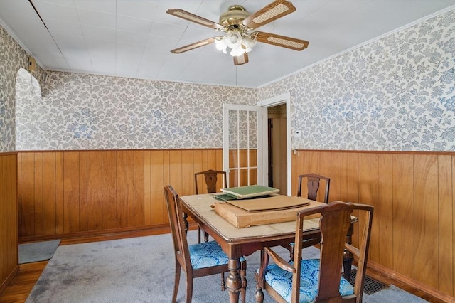 dining space featuring a wainscoted wall and wallpapered walls