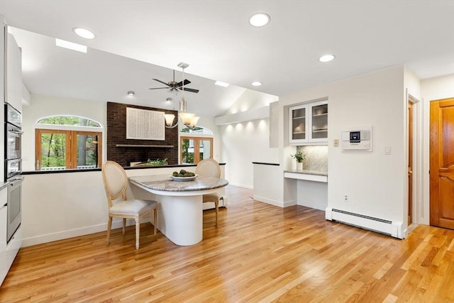 interior space with light wood-style floors, ceiling fan, baseboard heating, recessed lighting, and vaulted ceiling