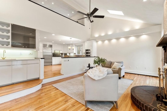 living room with ceiling fan, light wood finished floors, high vaulted ceiling, recessed lighting, and a baseboard radiator