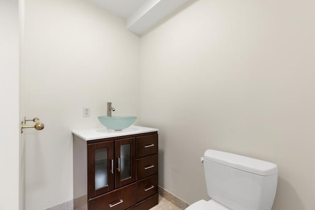 bathroom with toilet, baseboards, tile patterned flooring, and vanity