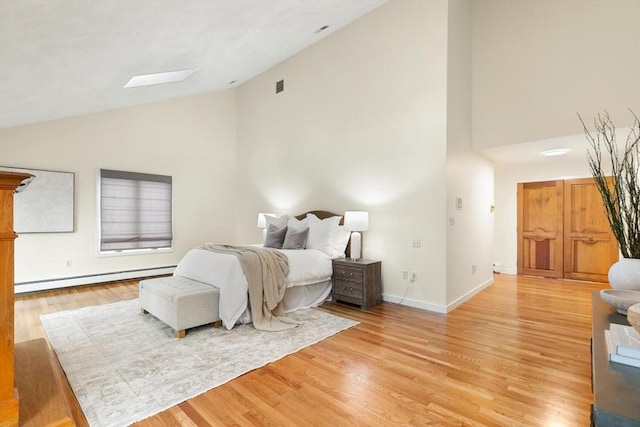 bedroom featuring visible vents, high vaulted ceiling, baseboards, a baseboard heating unit, and light wood finished floors