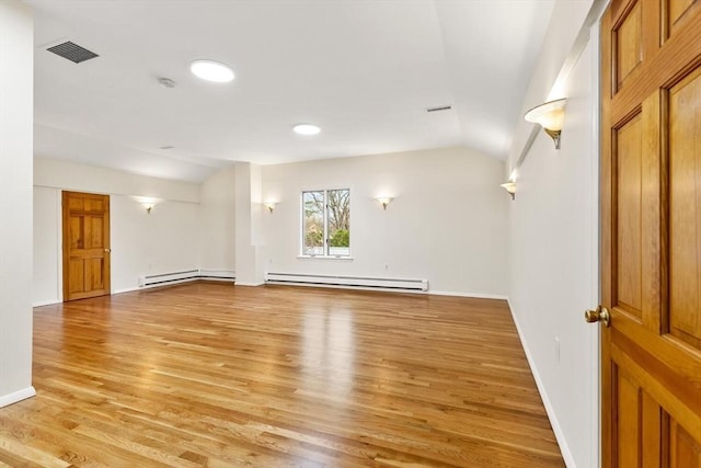 spare room featuring visible vents, light wood-style flooring, baseboards, a baseboard radiator, and vaulted ceiling