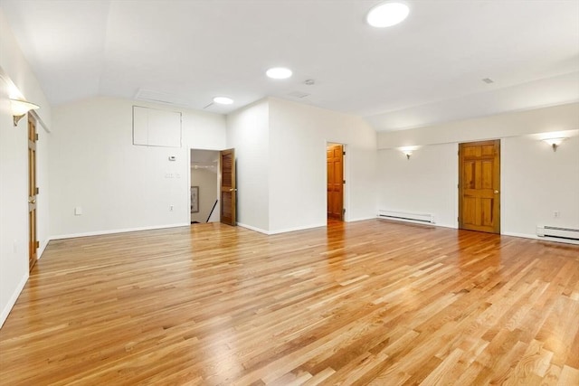 empty room with baseboards, vaulted ceiling, light wood-style flooring, and a baseboard radiator