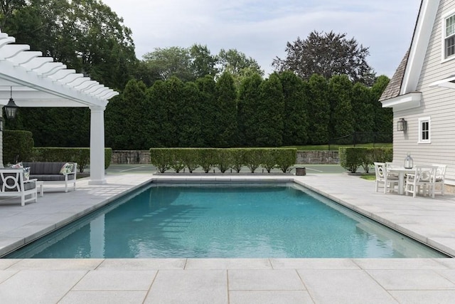 view of swimming pool featuring outdoor lounge area, fence, a patio, and a fenced in pool