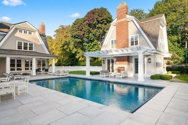 back of house featuring a gambrel roof, a chimney, fence, french doors, and a patio area