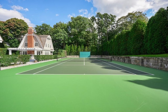 view of tennis court with a pergola, fence, and community basketball court