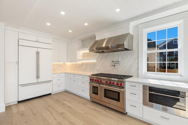 6 Mariner Way, Nantucket, MA 02564 - kitchen with white cabinetry, premium appliances, light wood finished floors, and wall chimney exhaust hood