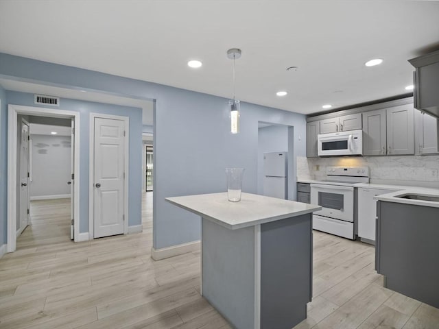 24 Bettys Pond Rd Unit K, Barnstable, MA 02601 - kitchen with white appliances, light countertops, a kitchen island, light wood-style floors, and recessed lighting