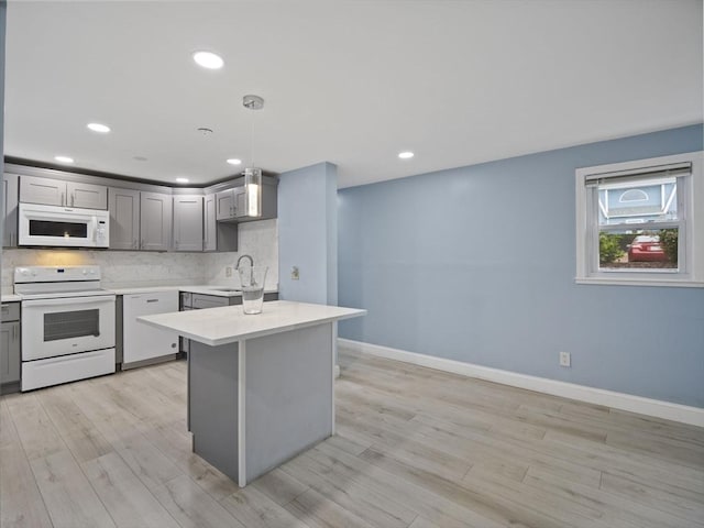 24 Bettys Pond Rd Unit K, Barnstable, MA 02601 - kitchen featuring white appliances, gray cabinets, light countertops, a sink, and light wood finished floors