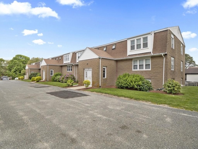 24 Bettys Pond Rd Unit K, Barnstable, MA 02601 - view of front of home featuring a shingled roof, brick siding, and a front yard
