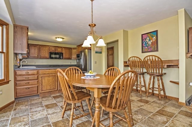 dining area featuring baseboards and stone finish floor