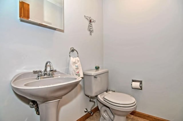 bathroom featuring toilet, baseboards, and tile patterned floors