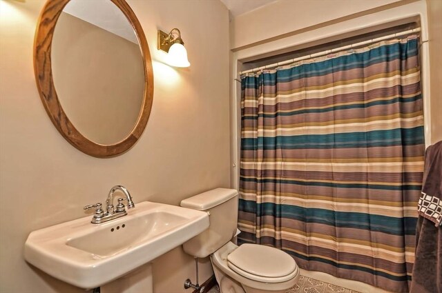 bathroom with a sink, a shower with curtain, and toilet