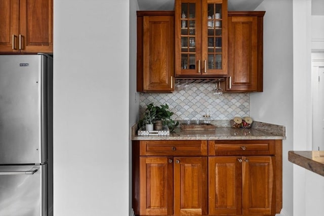 bar featuring backsplash and freestanding refrigerator