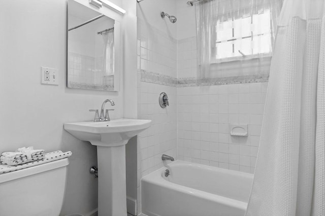 bathroom with a sink, toilet, and shower / tub combo with curtain