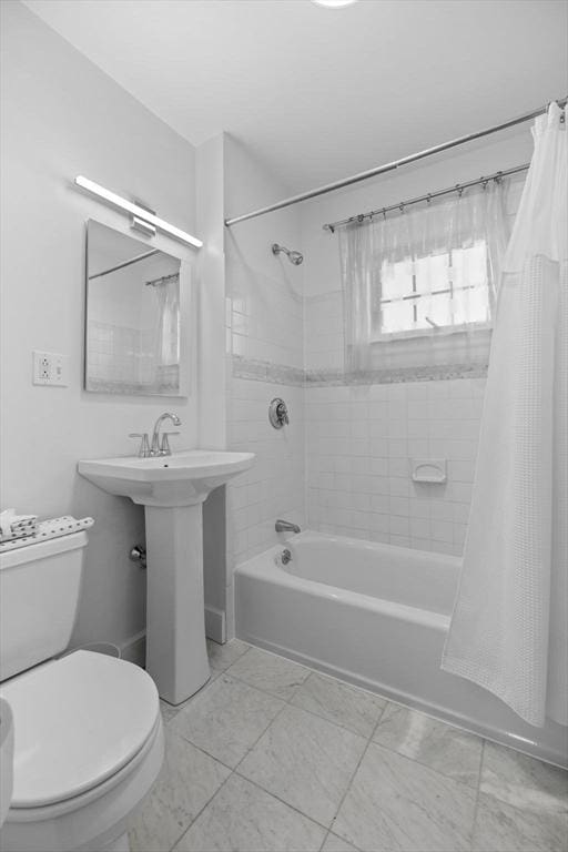 full bathroom with shower / bath combo, a sink, and toilet